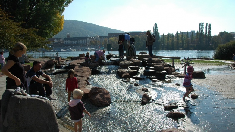 Das Beispielbild zeigt einen Wasserspielplatz im Gegenlicht.