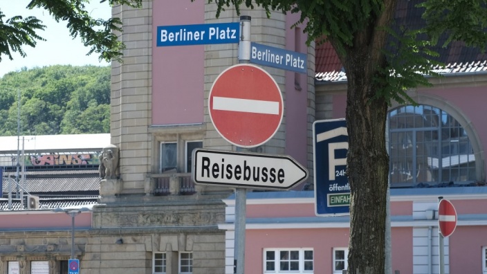 Das Bild zeigt das Hinweisschild für Reisebusse am Hagener Hauptbahnhof. Im Hintergrund: der Hauptbahnhof.